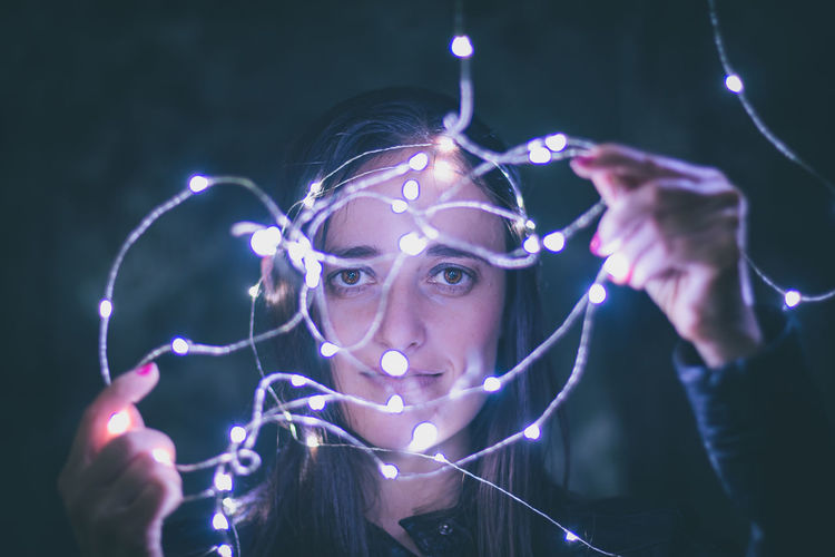 Close-up woman holding fairy lights