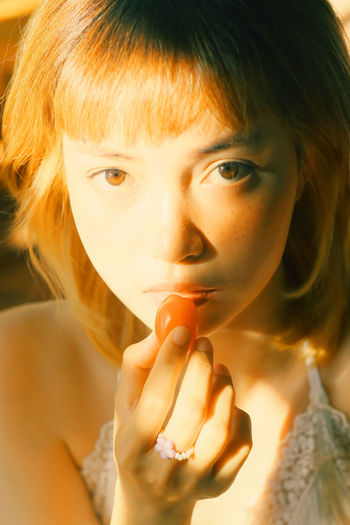 Close-up portrait of woman eating fruit