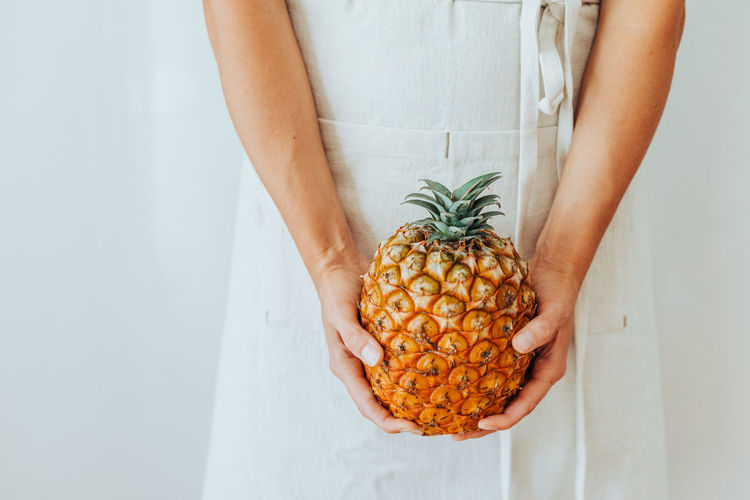 Close up of hands holding an azorean pineapple