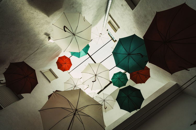 Low angle view of multi colored umbrellas on tiled floor
