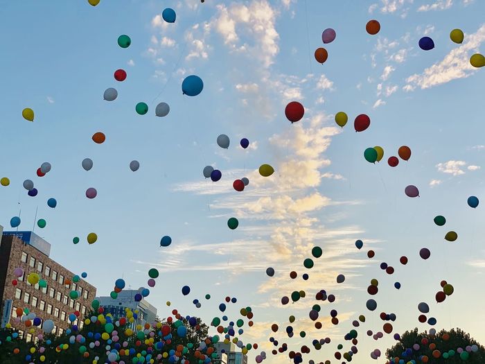Low angle view of balloons flying against sky
