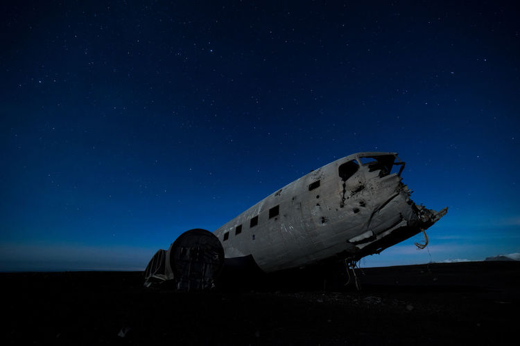 Abandoned airplane against star field at night