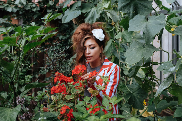 Portrait of a beautiful young woman standing by plants