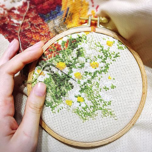 Cropped hands doing cross-stitch