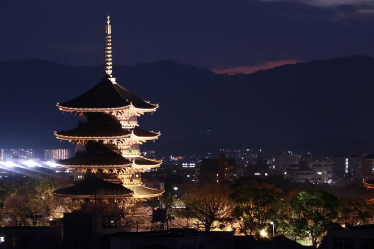 Illuminated pagoda in city at night