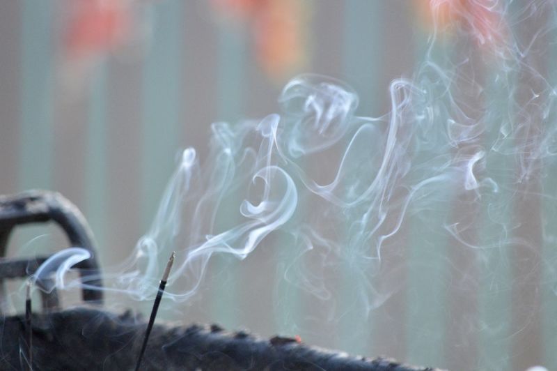 Close-up of emitting smoke from incense stick in temples in india