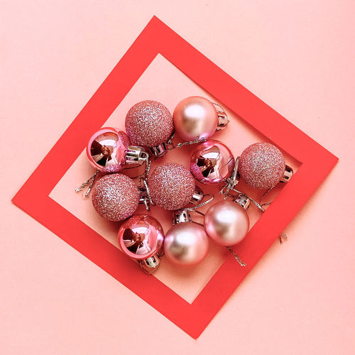 Directly above shot of christmas decorations on pink background