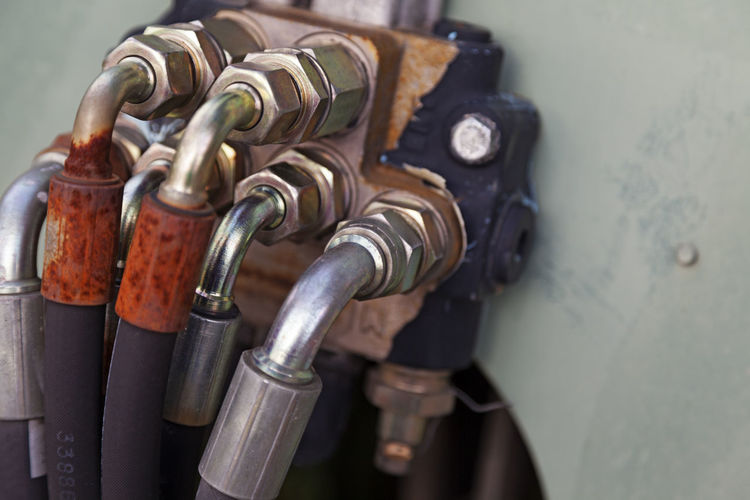 Several hoses mounted with silver-colored bolts are used for hydraulics