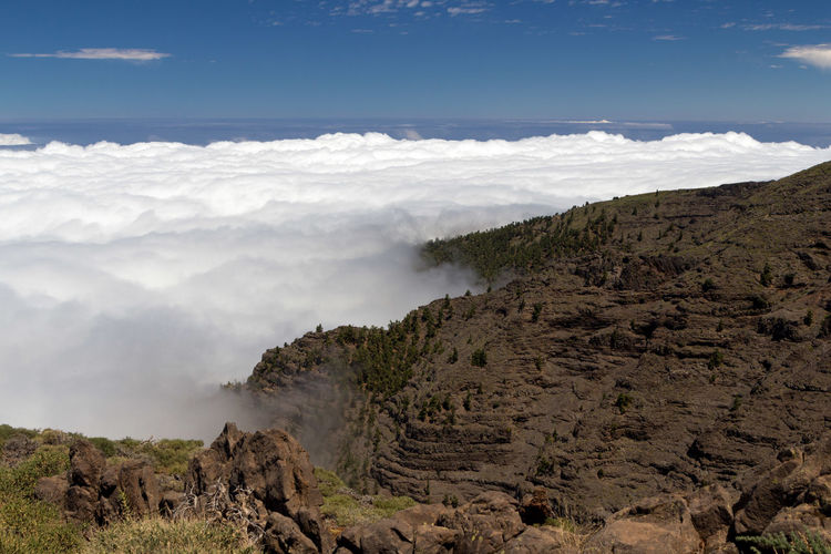 Scenic view of clouds over horizon from volcanic mountain submit against sky