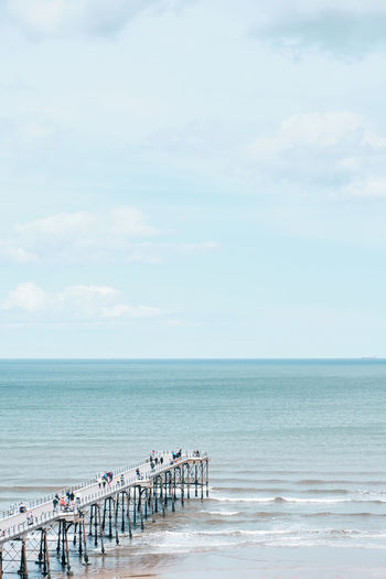 Group of people on beach against sky