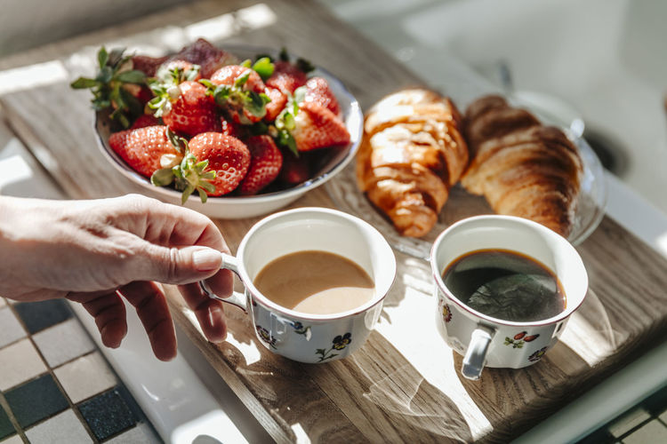 Strawberries, croissants and coffee in kitchen