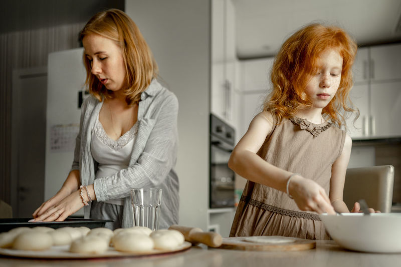 Mother and daughter making cheesecake at home