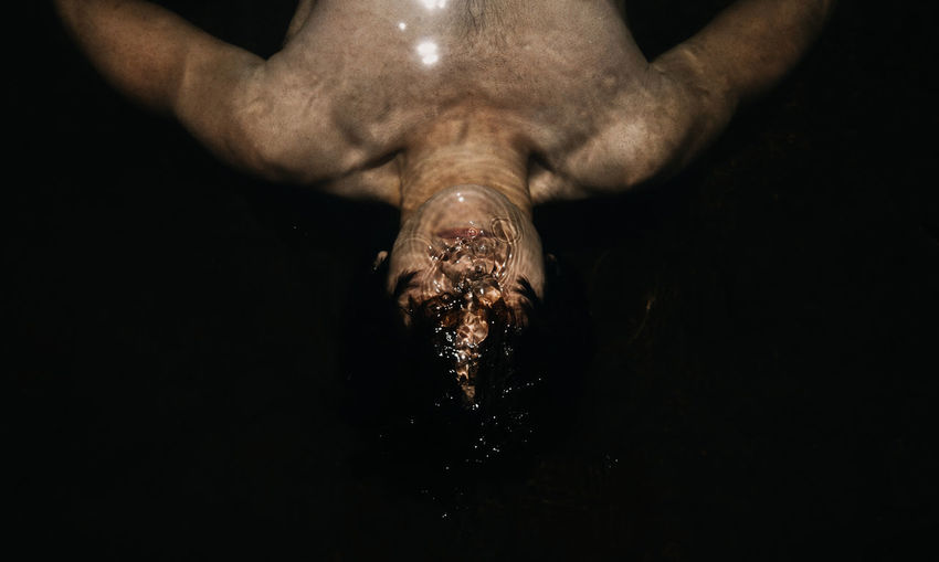 Close-up of shirtless man swimming in water