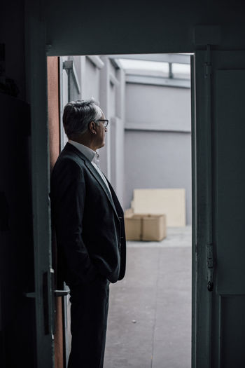 Senior businessman standing in door frame