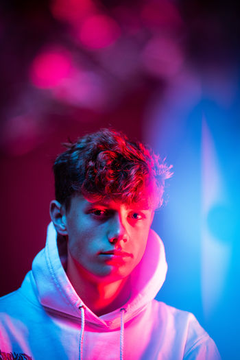 Portrait of a serious young man. blue and right lights in the bokeh 