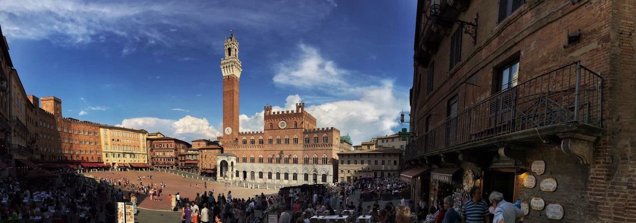 Panoramic view of torre del mangia at piazza del campo against sky