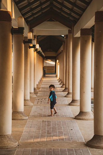Full length of boy walking in corridor of building