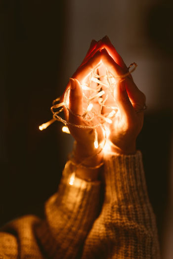 Close-up of man holding burning candle