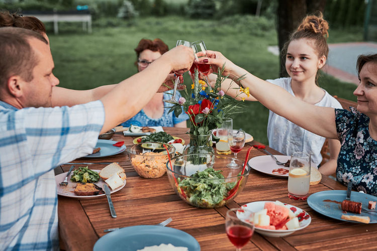Cheerful family toasting wine glass sitting outdoors