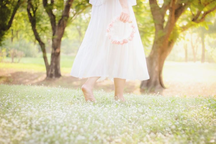 Low section of woman standing on field