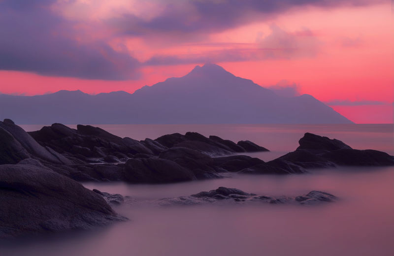 Scenic view of sea and mountains against sky during sunset