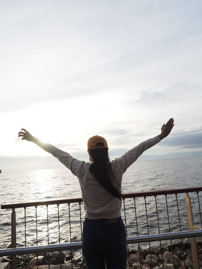 Rear view of man looking at sea against sky