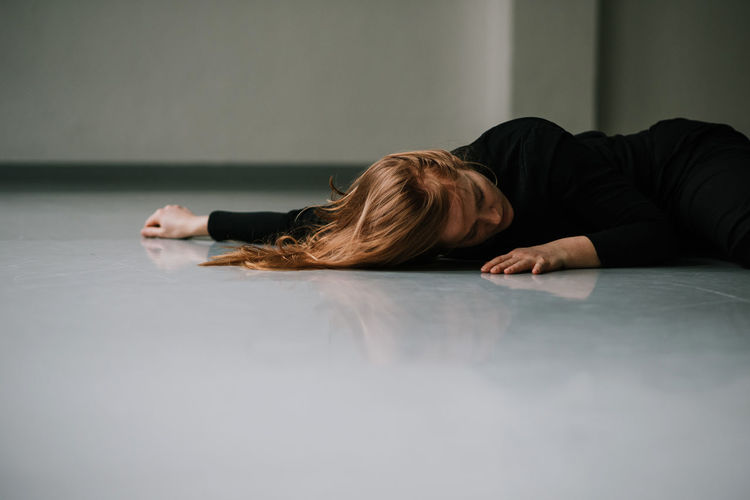 High angle view of woman dancing while lying on floor at home