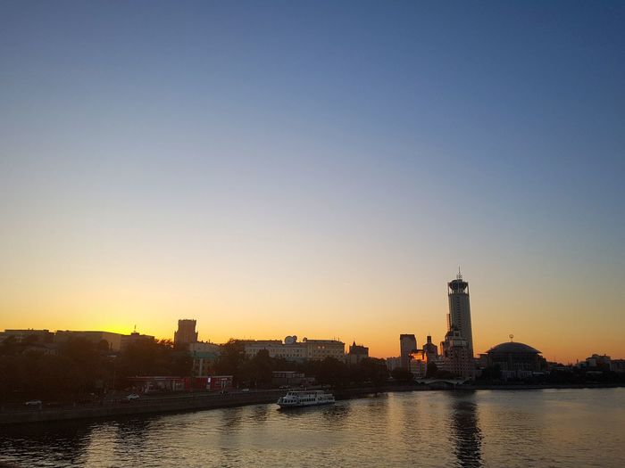 View of city at waterfront during sunset