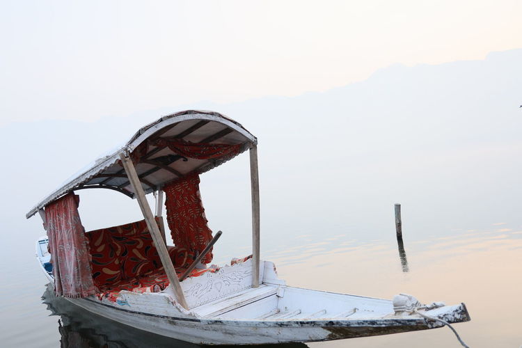 Ferris wheel by lake against sky during winter, shikara boat dal lake srinagar kashmir 