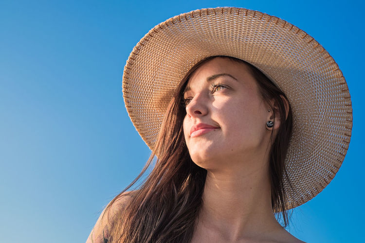 Woman looking at camera against clear sky