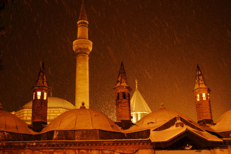 Mosque amidst buildings against sky at night