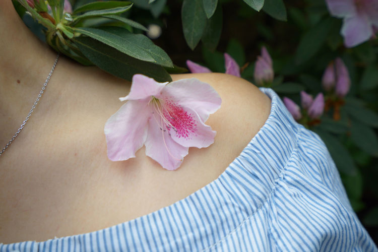 Close-up of flower on woman shoulder