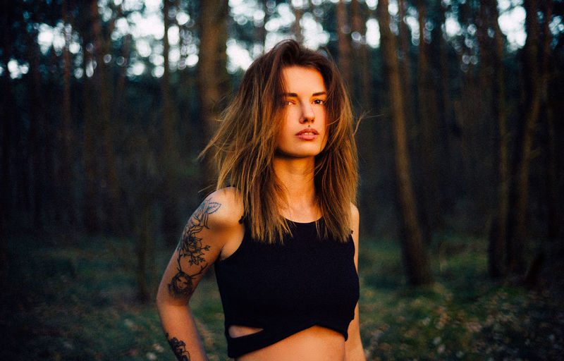 Portrait of beautiful young woman standing in forest