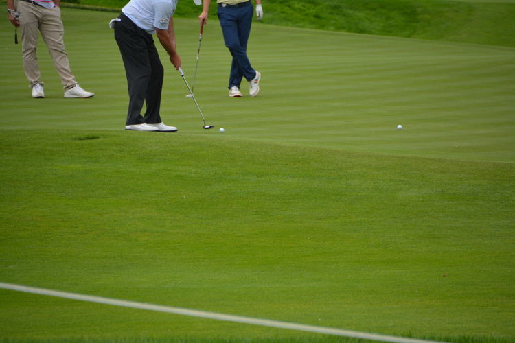 Low section of men standing of golf course