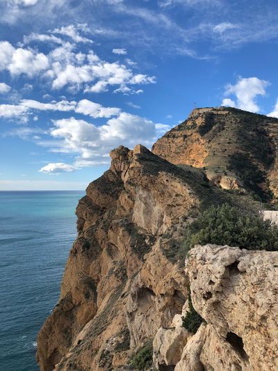 Rock formations by sea against sky