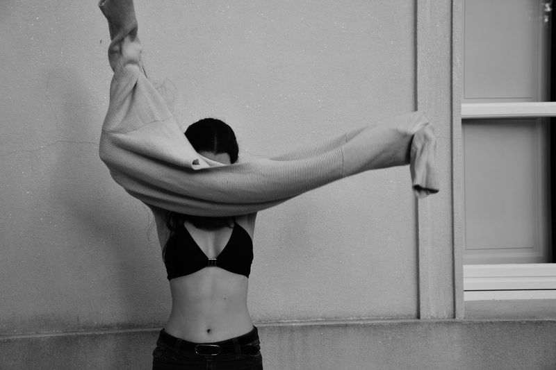 Woman wearing sweater against wall
