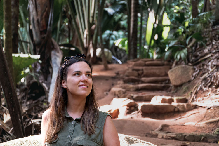 Portrait of an attractive young woman in tropical forest.