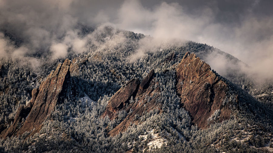 Snow and clouds cover the flatirons in boulder, colorado