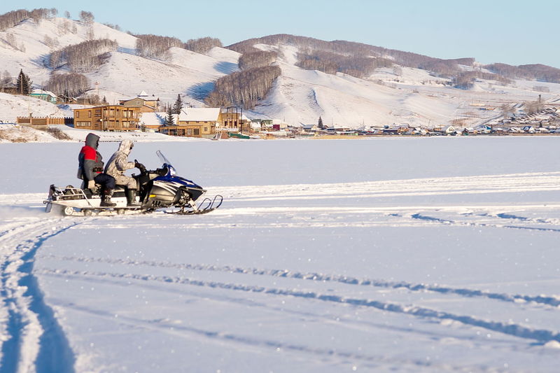 People skiing on snow covered field