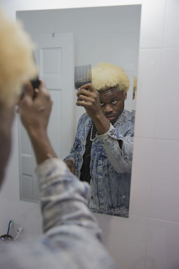 A young man getting ready in the mirror