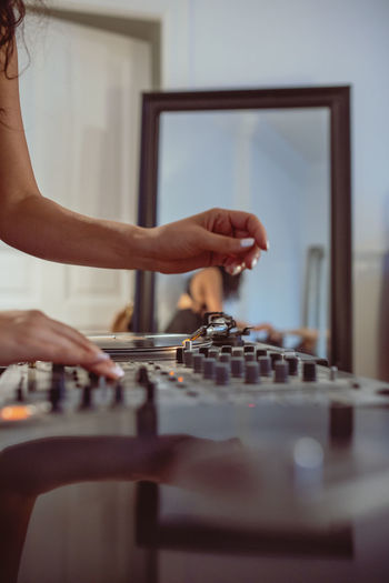 Cropped hand of woman playing sound mixer at home