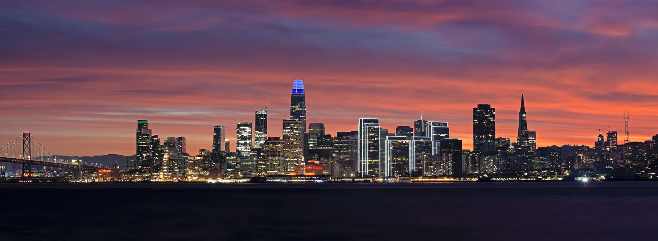 Illuminated cityscape against sky at night