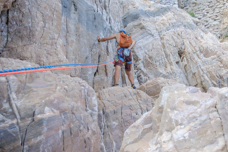Low angle view of man climbing on mountain