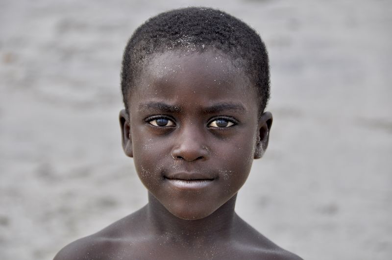 Close-up portrait of shirtless boy at beach