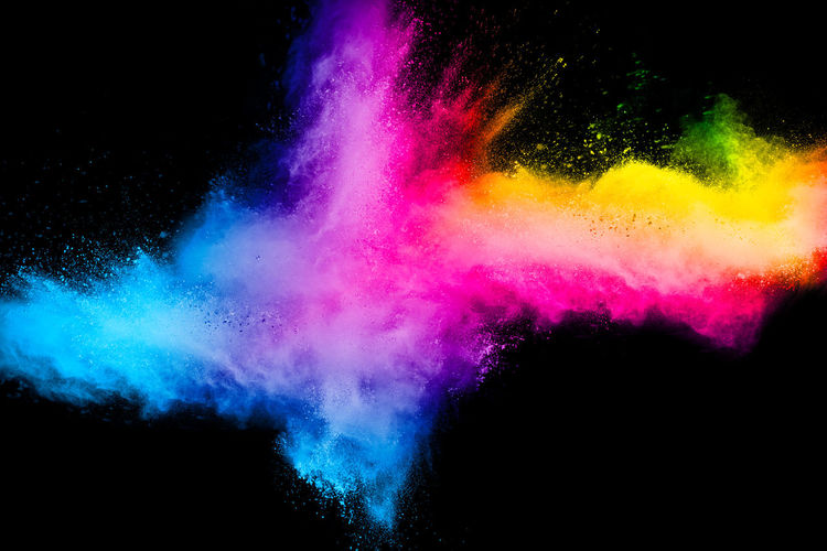 Defocused image of multi colored powder paints against black background