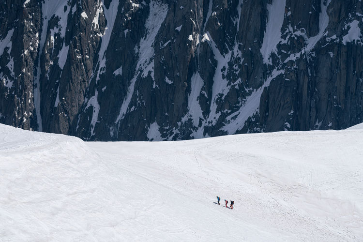High angle view of people hiking on snowcapped mountain