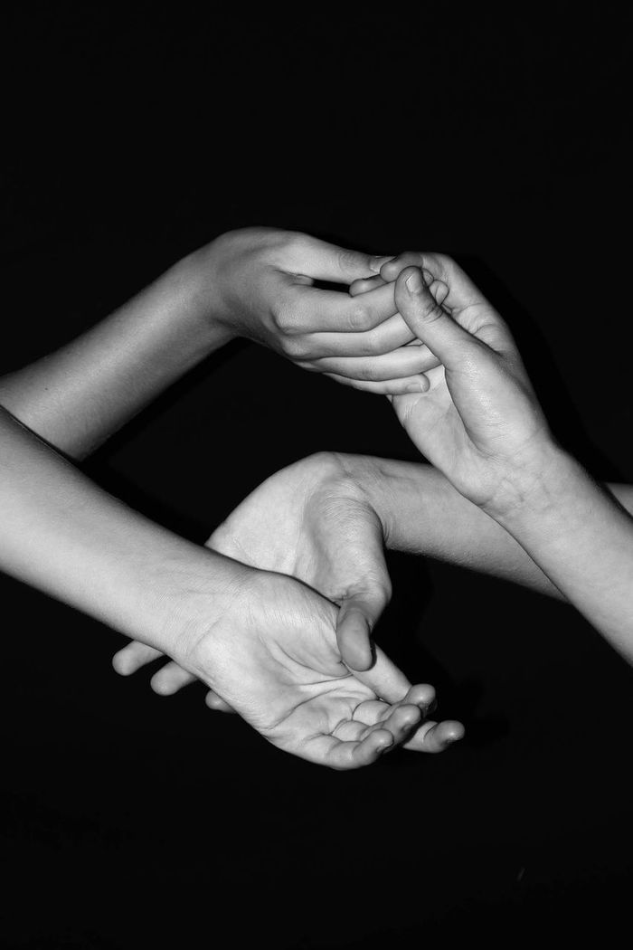 Cropped hands of people against black background