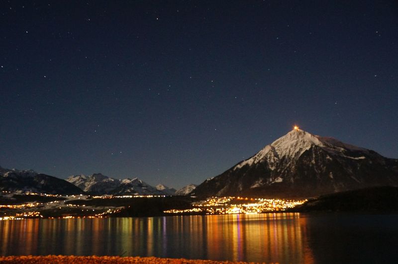 River with illuminated structures in distance
