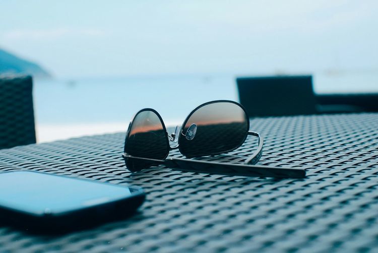 Close-up of sunglasses and smart phone on table