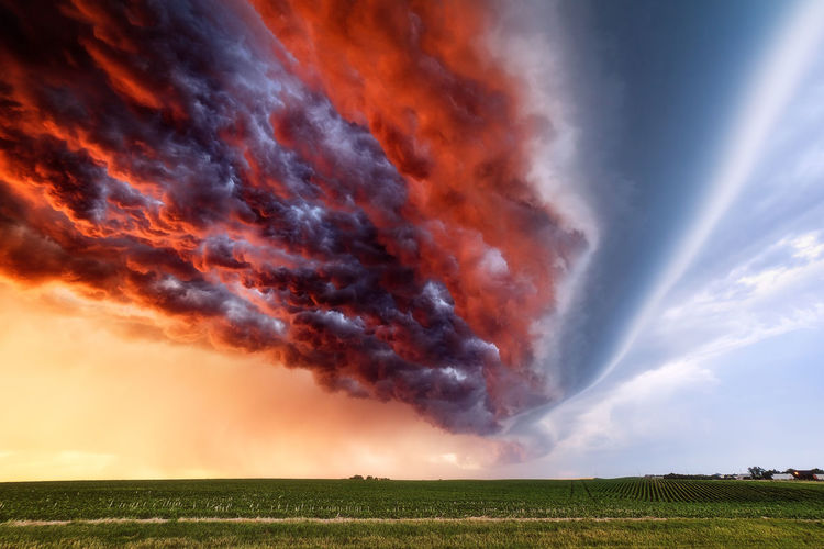 Sunset illuminates a turbulent sky beneath a shelf cloud ahead of an advancing storm.